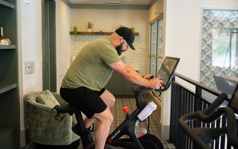 Resident Using Peloton Equipment in Fitness Center